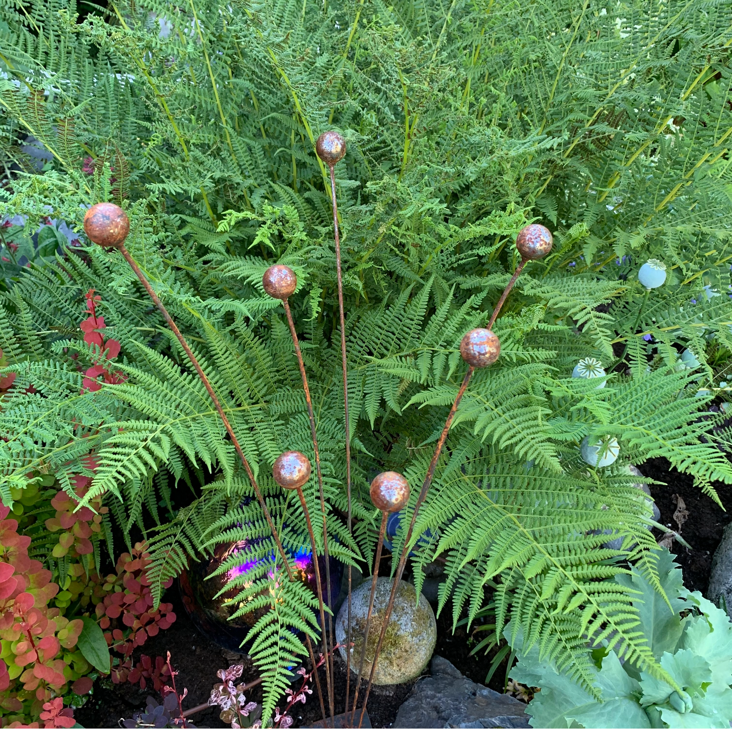 Kinetic Steel garden art, 7 buds on stems in ferns